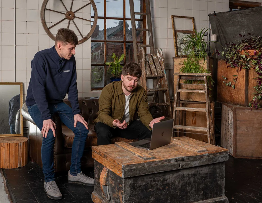 Josh who is a web developer and Callum who is a web designer, who both work at Yellow Circle Web Solutions Limited discuss UI and UX design for a website they are developing.
