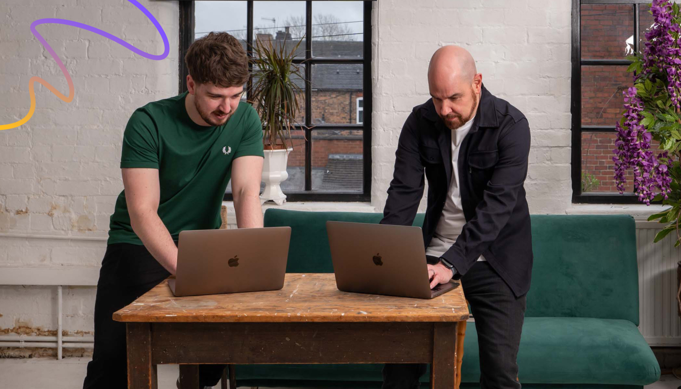 An image of Ian Hazeldine and Callum Williams from Yellow Circle Web Solutions Limited, one of the few agencies in 2025 offering specialised GEO services, working on Macbooks, optimising client's sites and business to be found and chosen by AI search engines.