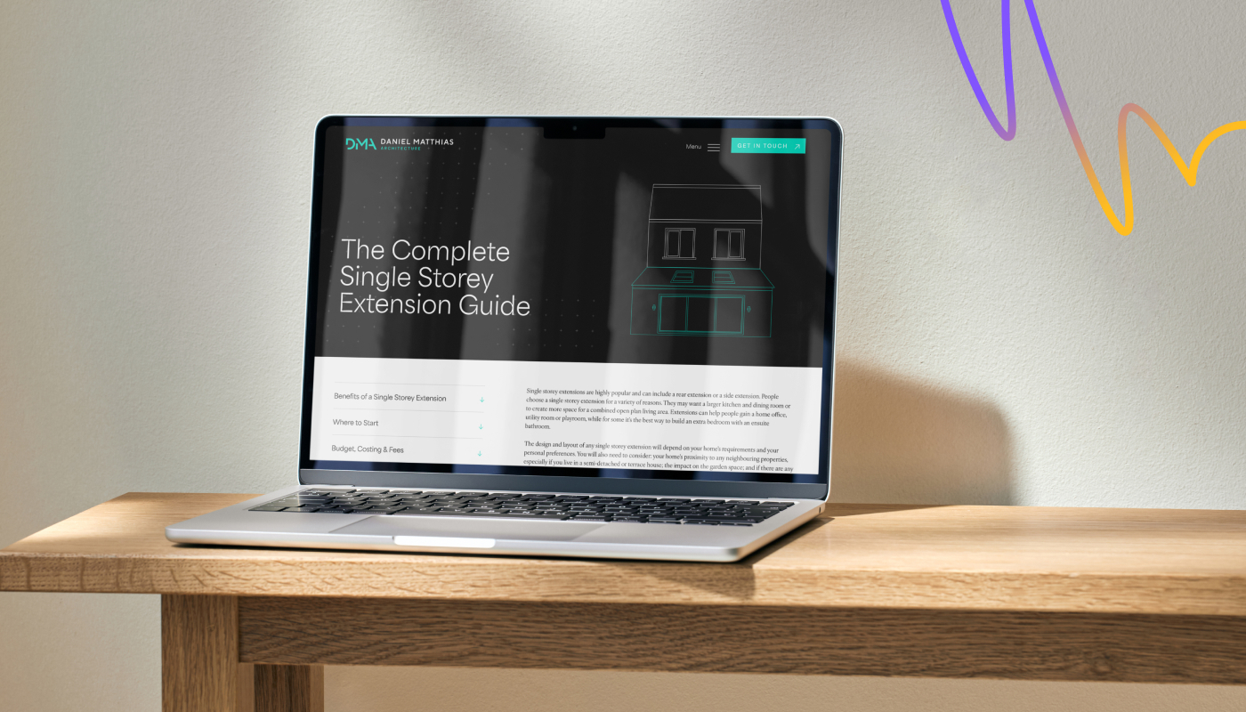 An image of a client's website shown on a Macbook laptop, on a desk.
