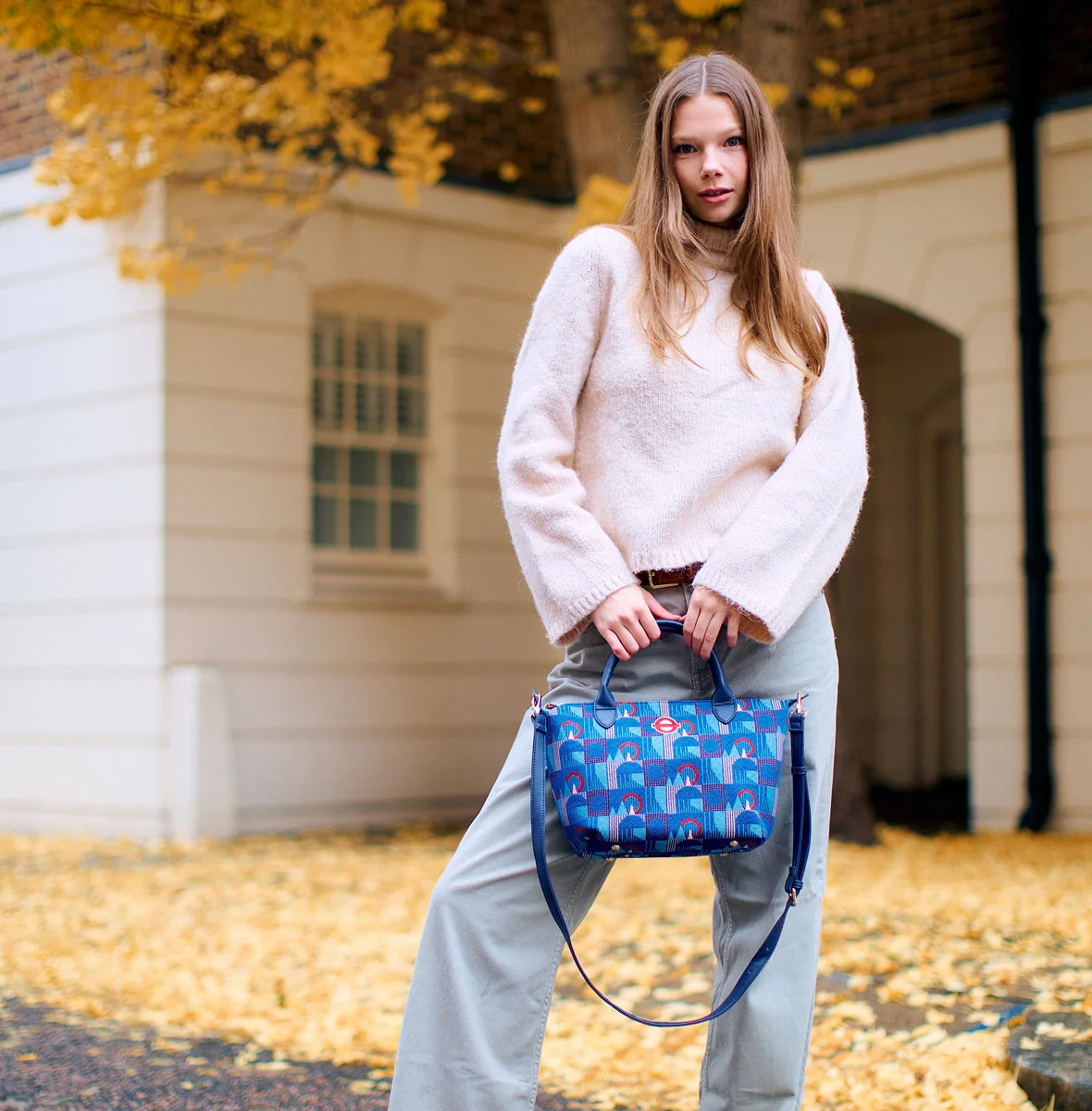 Woman outside holding a blue Signare bag