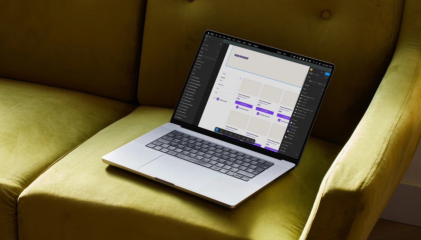 laptop on green sofa with web design on screen