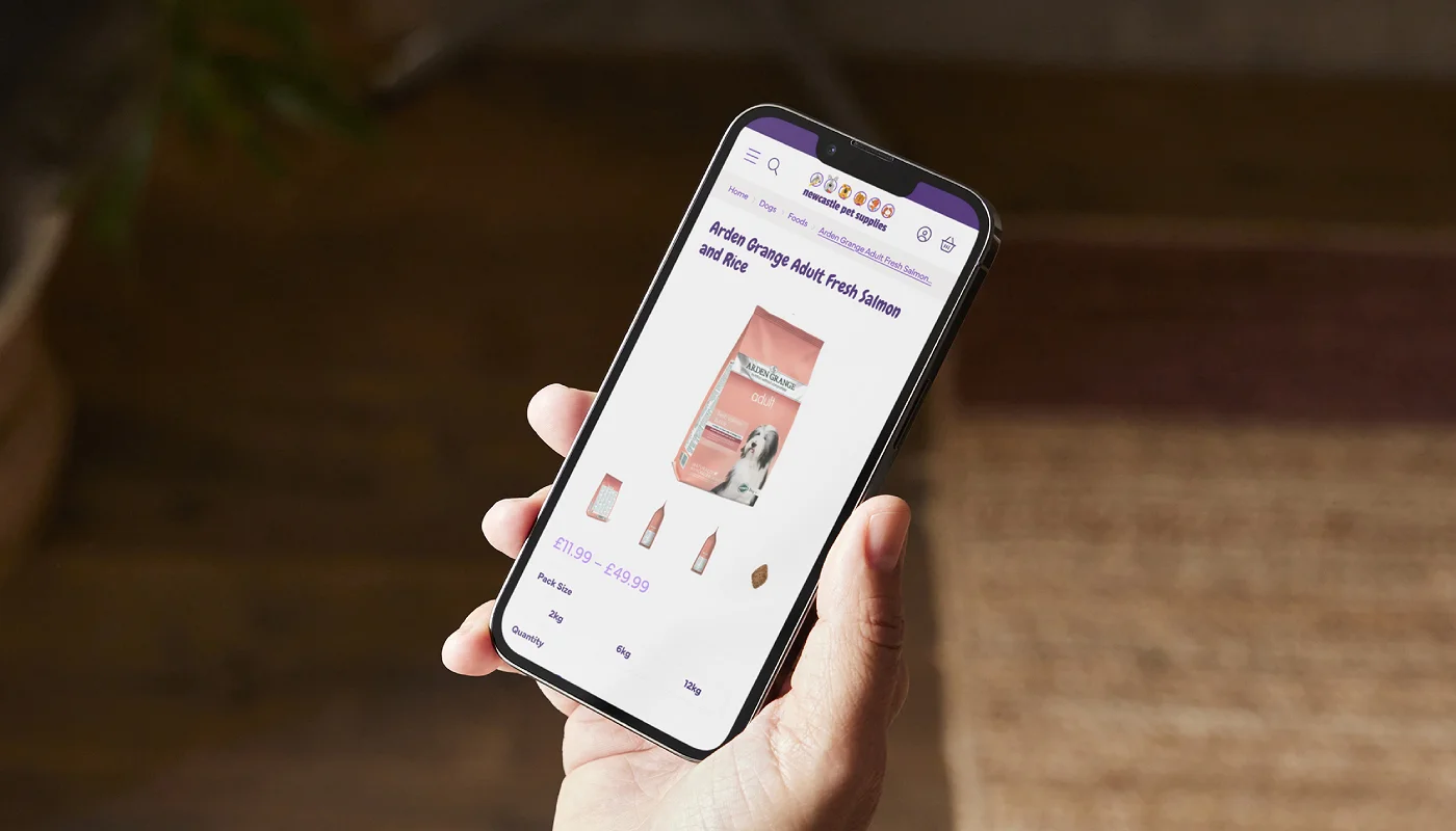 hand holding a mobile phone displaying a pet shop ecommerce store