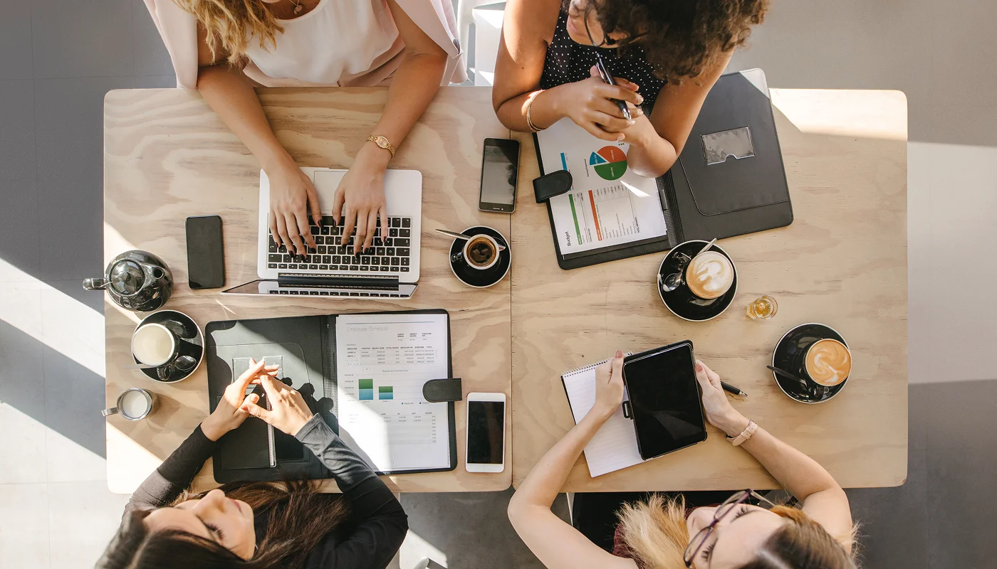 Birds eye view shot of a marketing team working at a shared desk