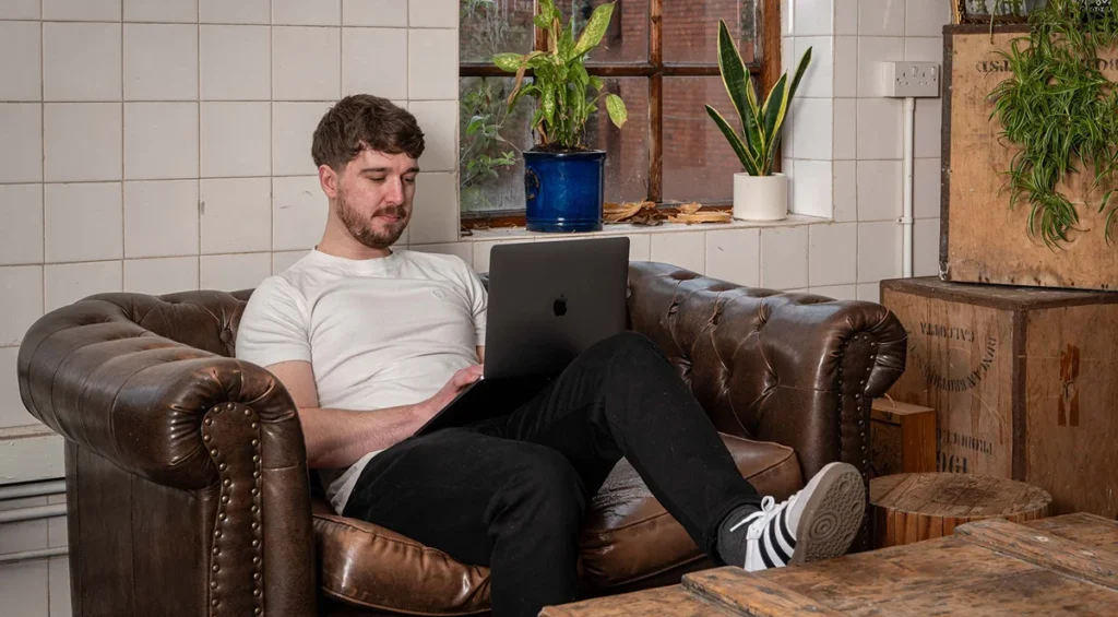 ux designer working on laptop from sofa