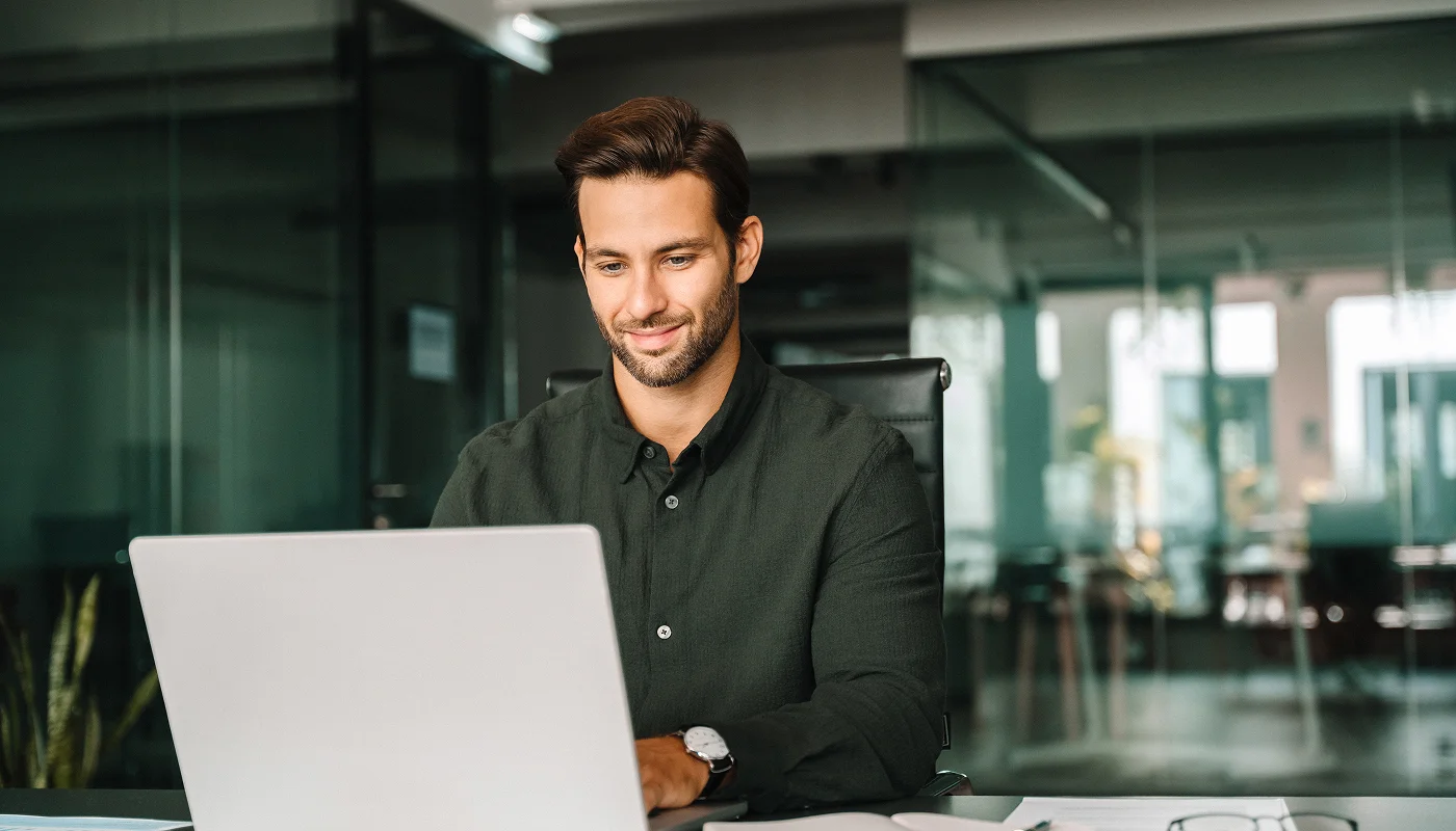smiling man using laptop research how to clear cache on wordpress