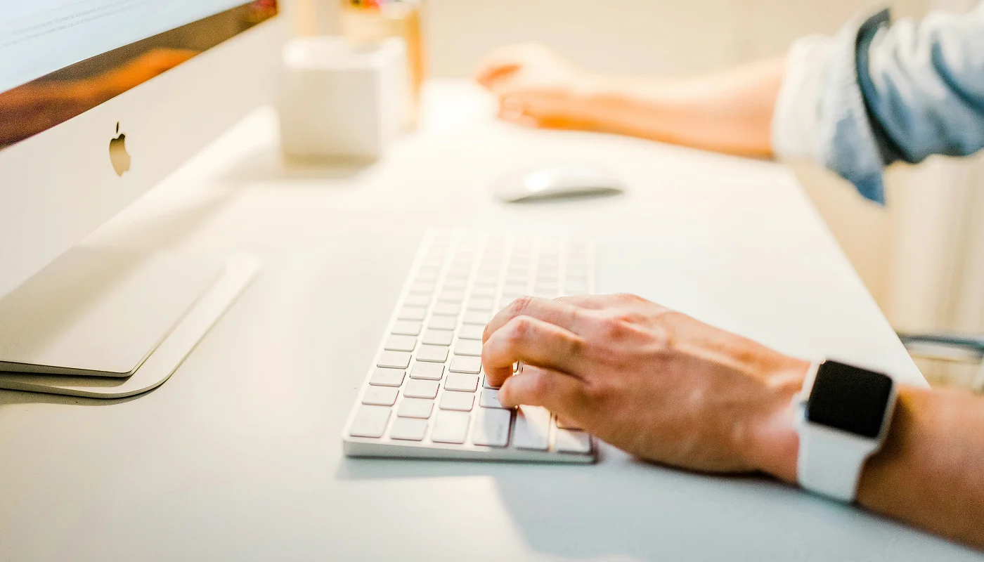 content writer wearing a smart watch using a keyboard on a desk